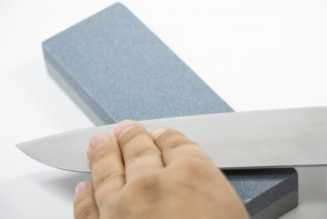 Whetstone sharpening technique showing blade angle against the stone