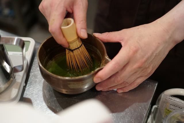 Whisking matcha in a chawan using a bamboo chasen