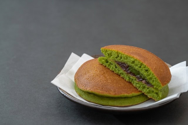 Matcha dorayaki cut in half showing red bean paste filling