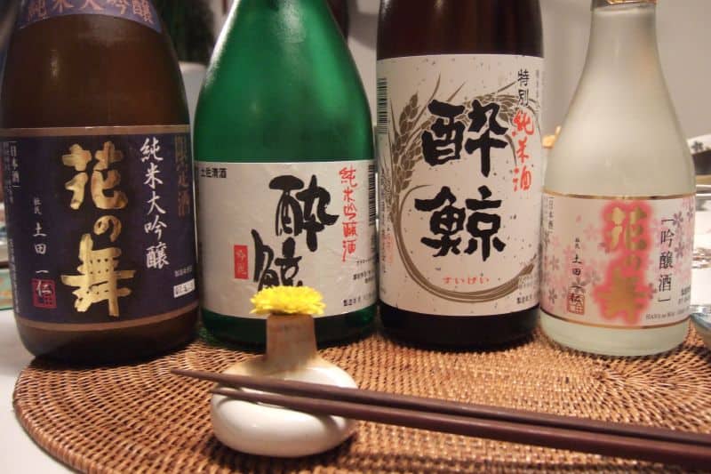 Sake bottles arranged for a tasting with chopsticks