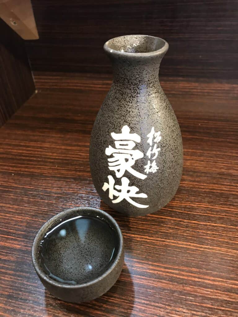 Ceramic tokkuri flask and ochoko cup on a restaurant table in Osaka