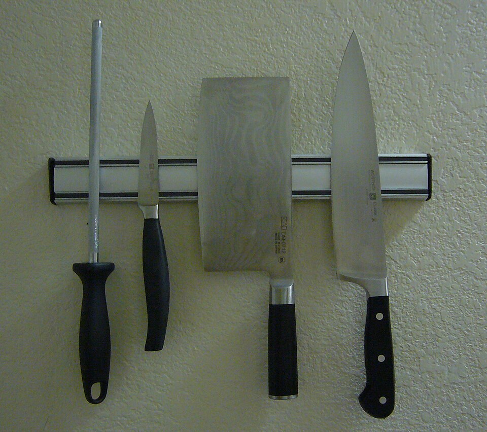 Kitchen knives arranged on a wall-mounted knife rack